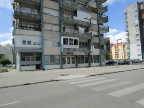 Exterior view of a residential building with commercial space on the ground floor. - image 6