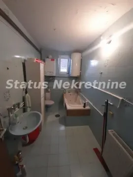 Starije uređeno kupatilo sa kadom, umivaonikom i pločicama na zidovima. - image 13