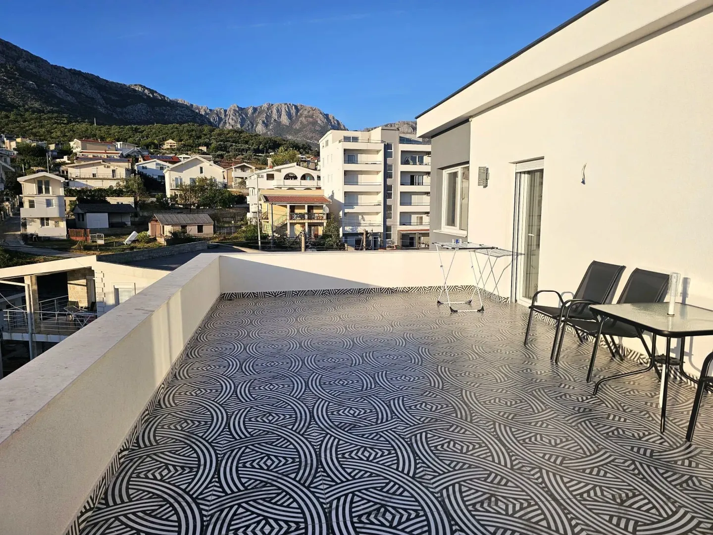 Large terrace with tiled flooring and views of the neighborhood and mountains.