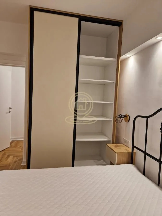 Spavaća soba sa velikim ugradnim garderoberom i bračnim krevetom.