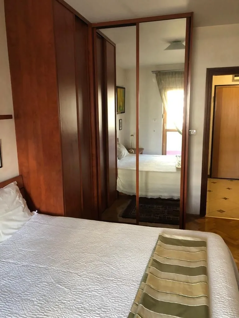 Bright bedroom featuring a large built-in wardrobe with mirrored doors.