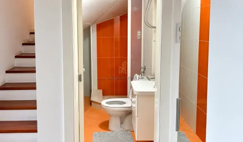 View of the bathroom with orange tiles and stairs on the left. - image 6