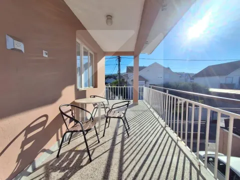 Covered balcony with outdoor seating and a view of the surroundings. - image 9