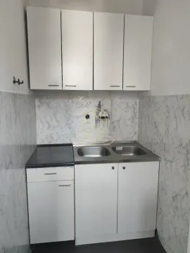 Smaller kitchen with white cabinetry and a double sink. - image 7
