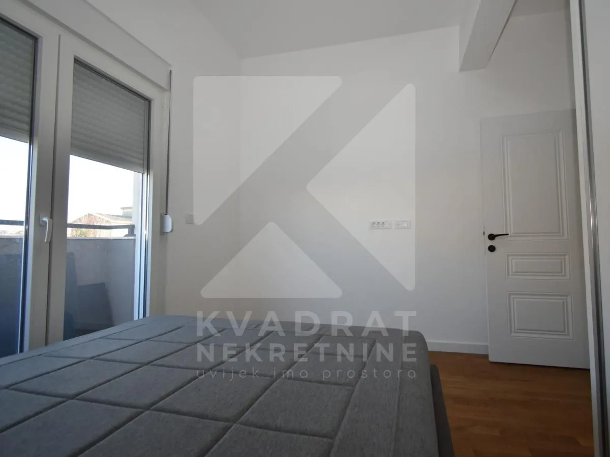 Bedroom with a bed, white walls and access to the terrace.