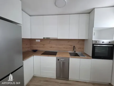 Modern white kitchen with a wooden countertop and built-in appliances. - image 5