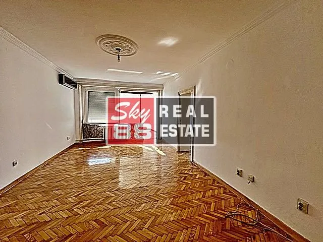 Empty living room with hardwood floors and access to the terrace.