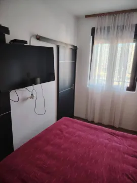 Spavaća soba sa bračnim krevetom, televizorom na zidu i prozorom sa zavjesama. - image 7