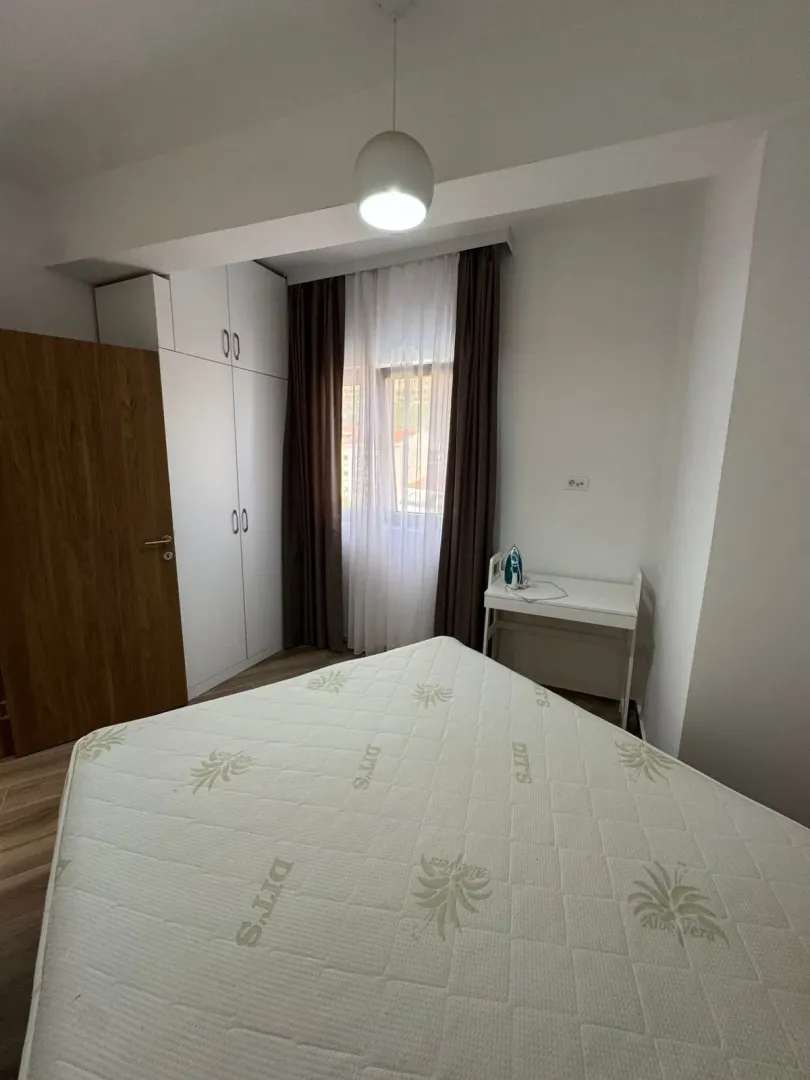 Small bedroom with a bed, wardrobe, and window.