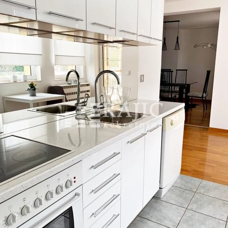 Modern white kitchen with an island and built-in appliances.