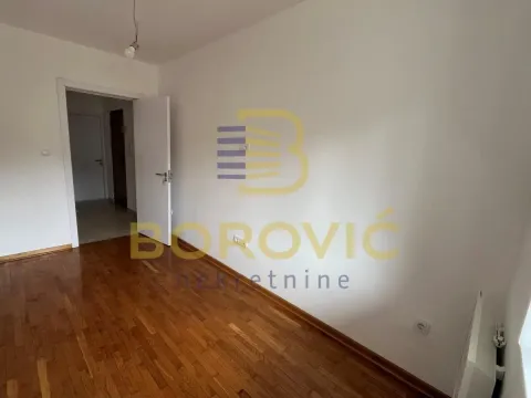 Prazna soba sa parketom i otvorenim vratima prema hodniku. - image 10