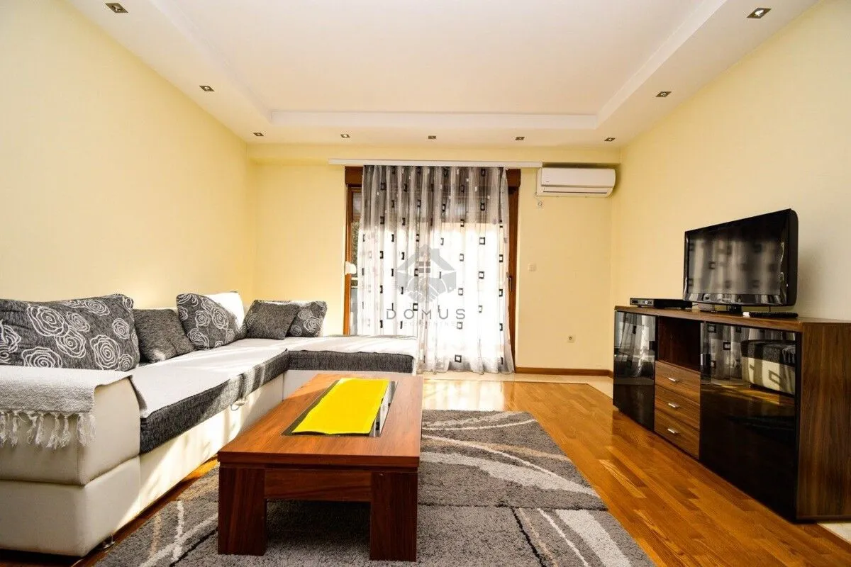 Living room with sofa, coffee table and television.