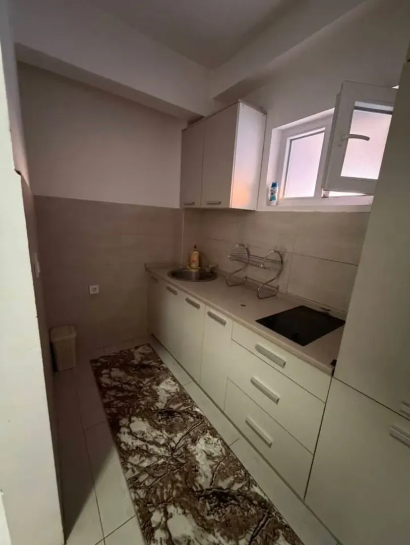 Small kitchen with white units and a sink.