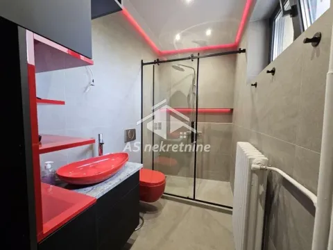 Moderno kupatilo sa tuš kabinom i crvenim detaljima. - image 10