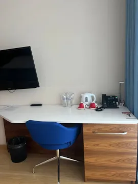 A desk with a chair and a wall-mounted TV in the room. - image 7