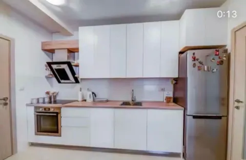 Modern kitchen with white cabinetry, built-in appliances, and a refrigerator. - image 5
