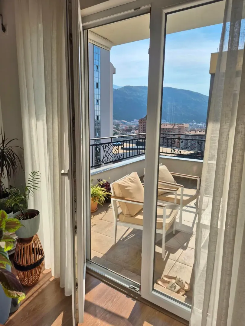Furnished terrace with seating furniture and a view of the city and mountains.