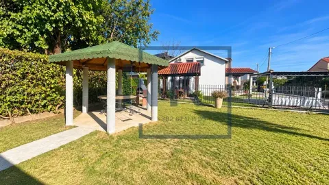 Landscaped yard with a lawn, covered gazebo, and barbecue. - image 5