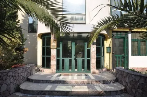 Building entrance with decorative palm trees and stone details. - image 3
