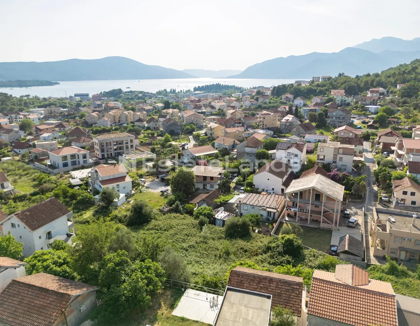 Pogled iz vazduha na naselje i more u daljini.