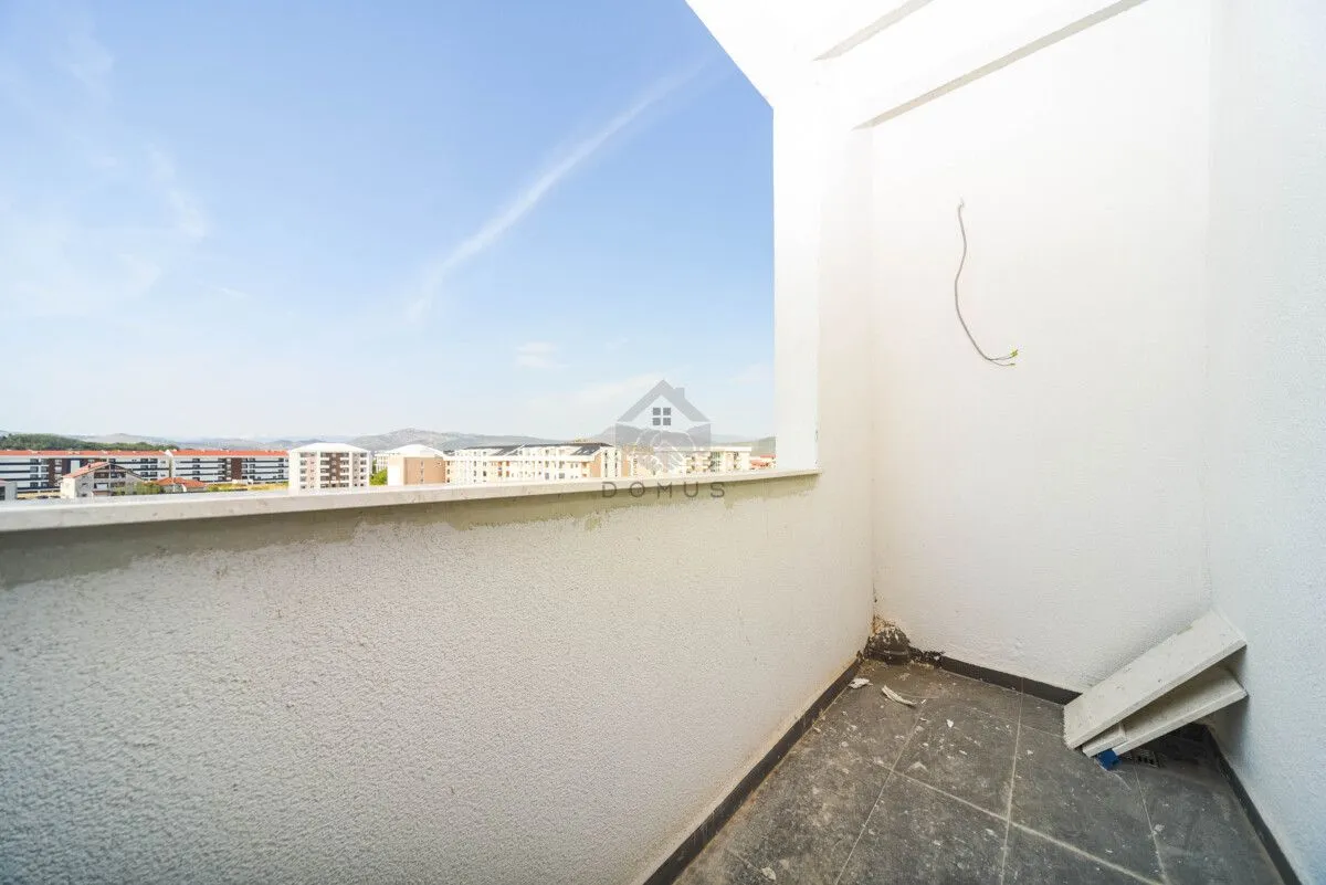Neopremljen balkon sa pogledom na grad.