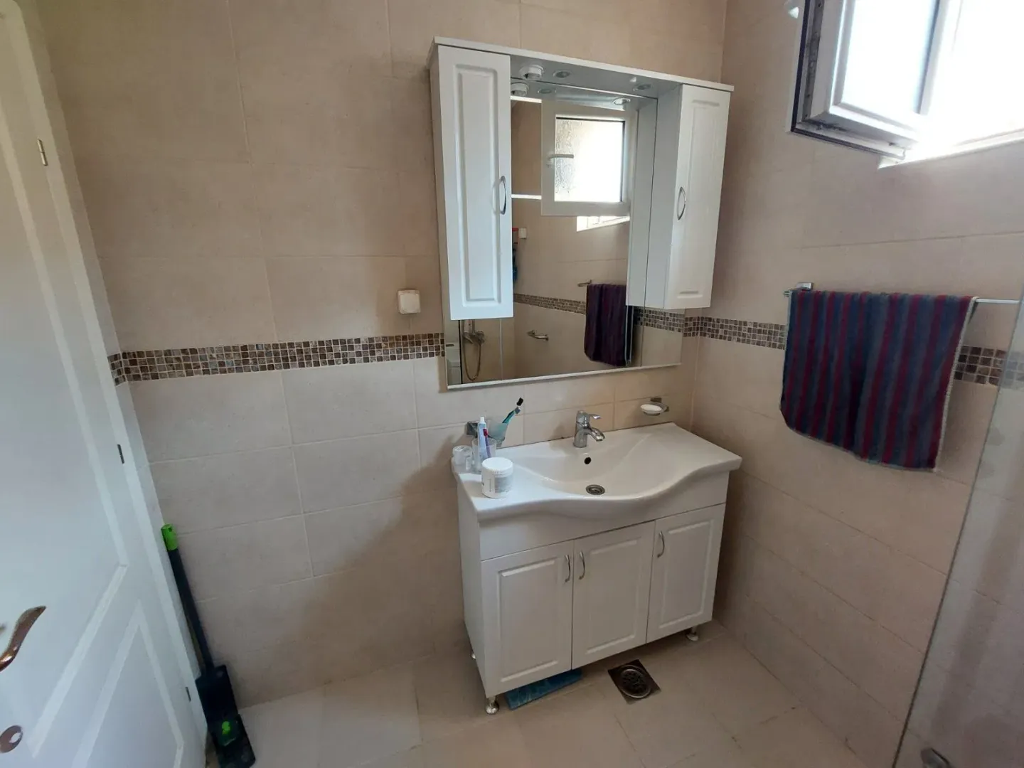 Simple bathroom with a white cabinet and mirror.