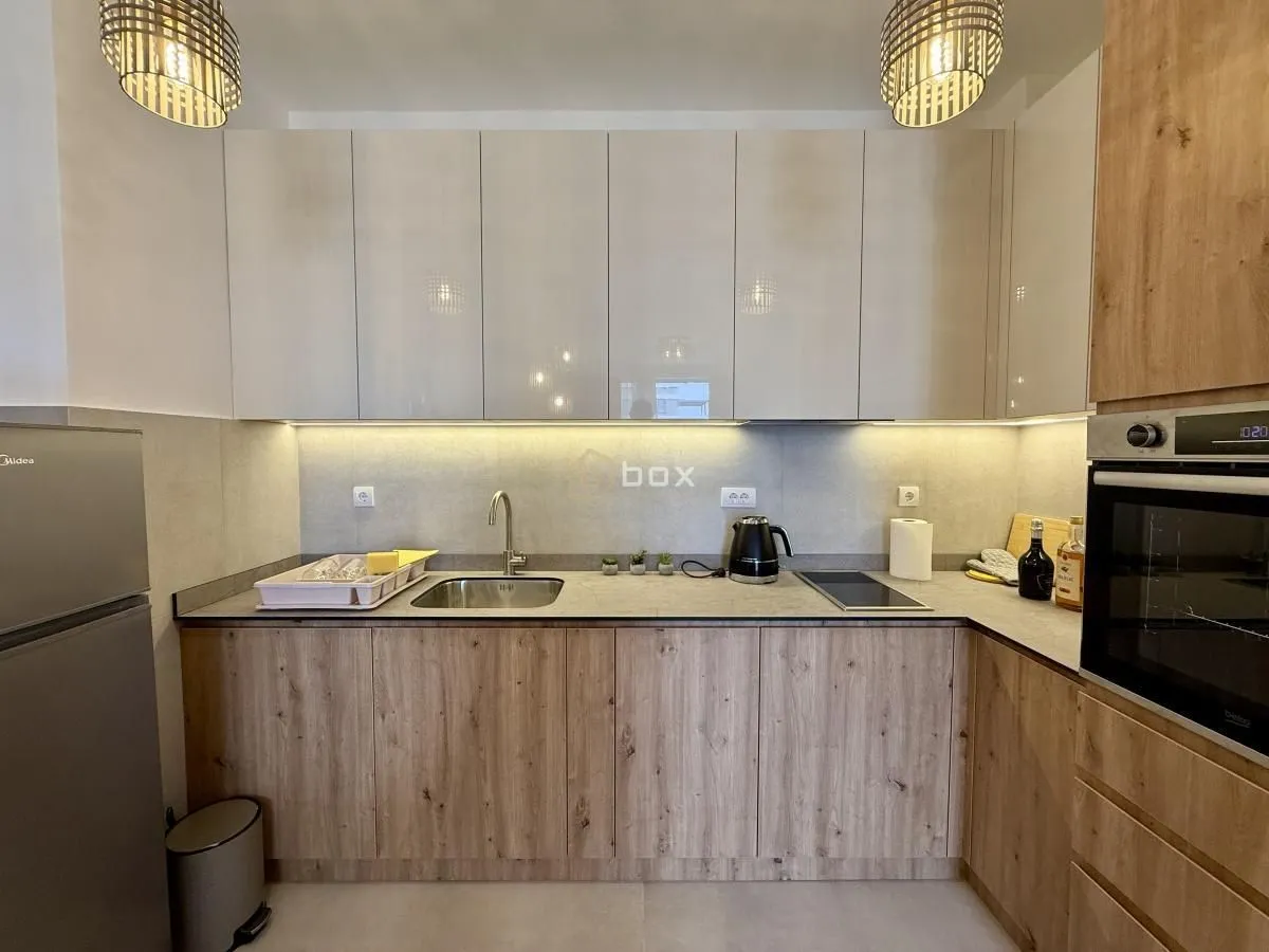 Modern kitchen with wooden cabinetry and built-in appliances.