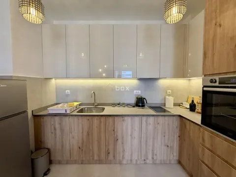 Modern kitchen with wooden cabinetry and built-in appliances. - image 8