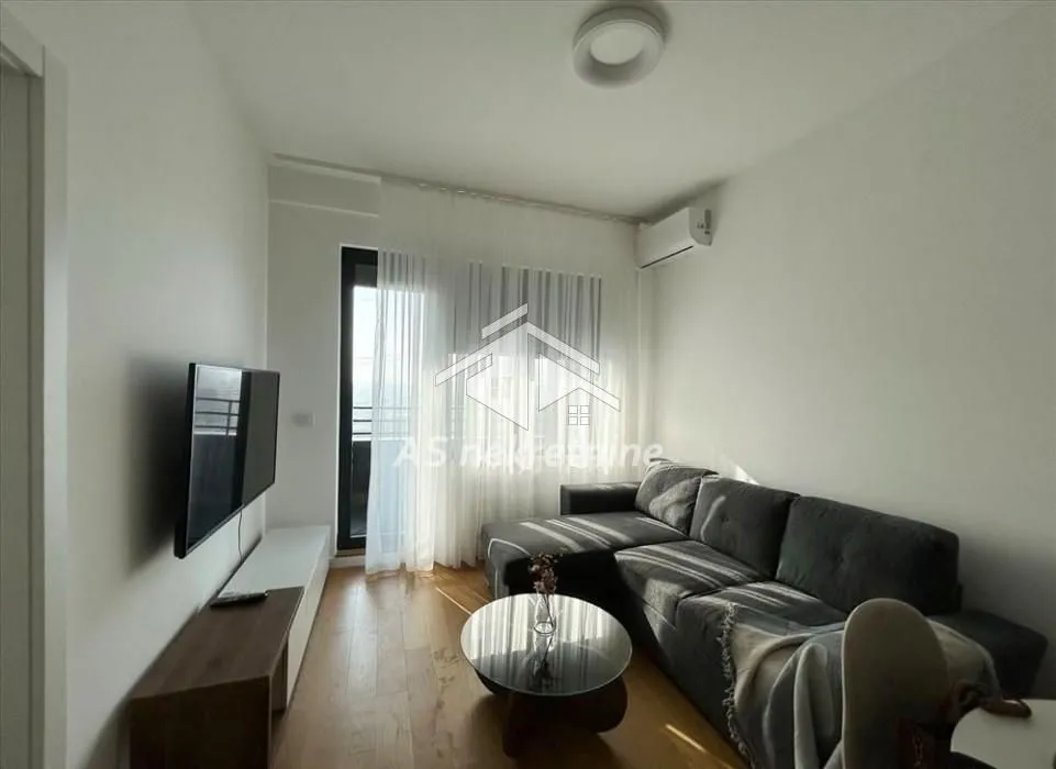 Living room with a sectional sofa, TV, and access to the terrace.
