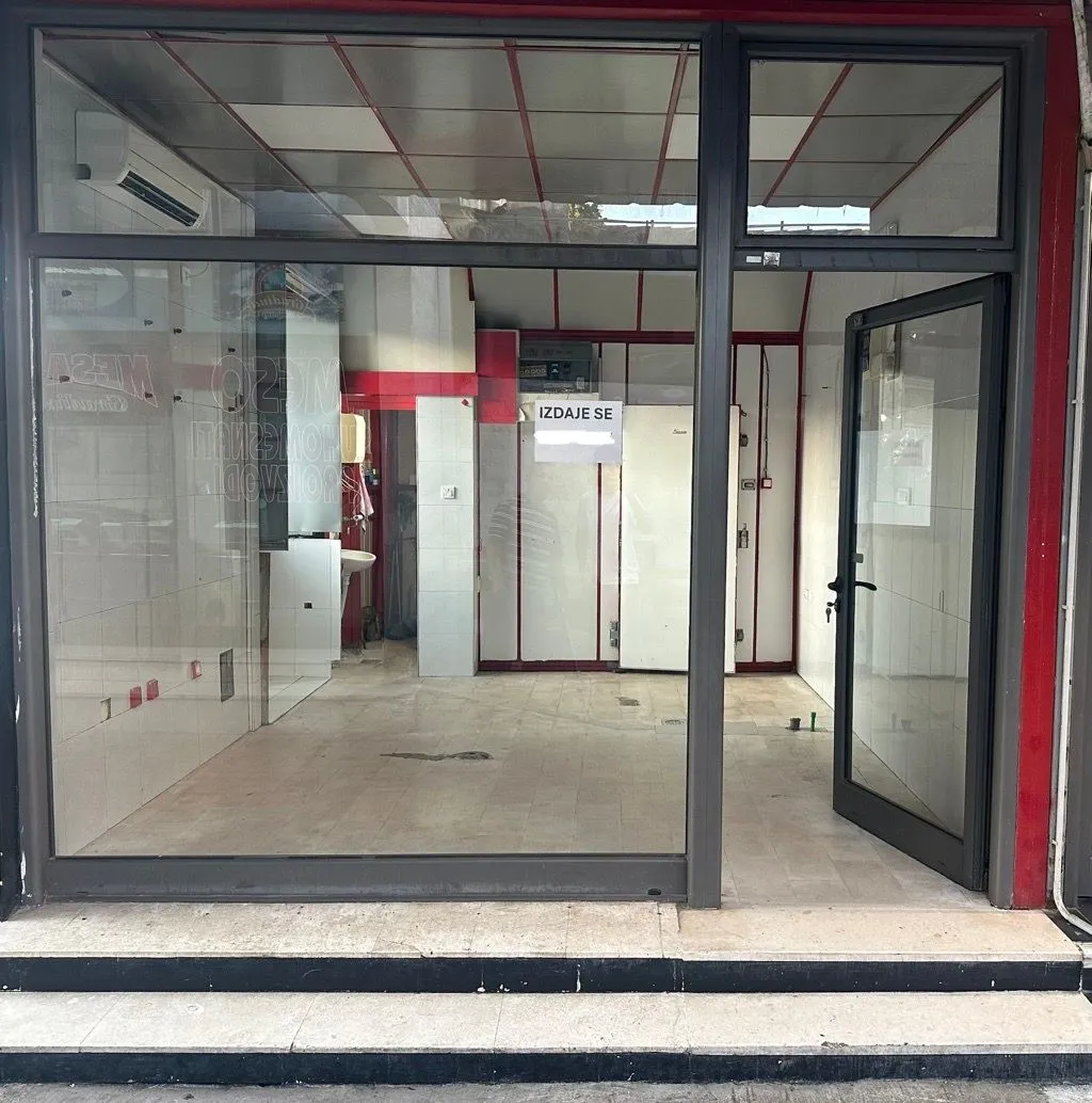 Exterior of a commercial space with a glass storefront and entrance door.