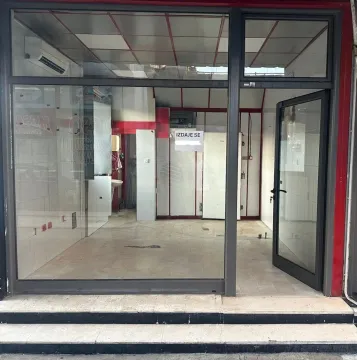 Exterior of a commercial space with a glass storefront and entrance door. - image 2