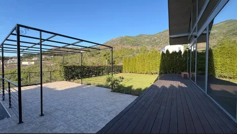 Prostrano dvorište sa terasom i metalnom konstrukcijom pergole ispred kuće. - image 12