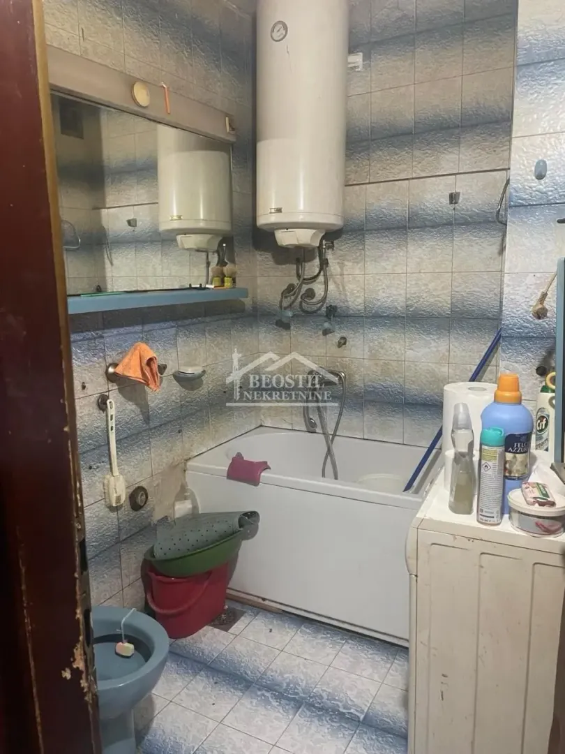 Manje kupatilo sa kadom, bojlerom, toaletom i sanitarijama.