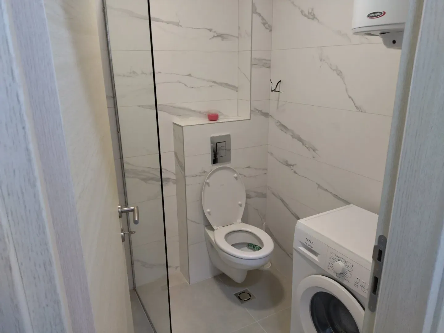 Modernly equipped bathroom with sanitary fixtures and a washing machine.