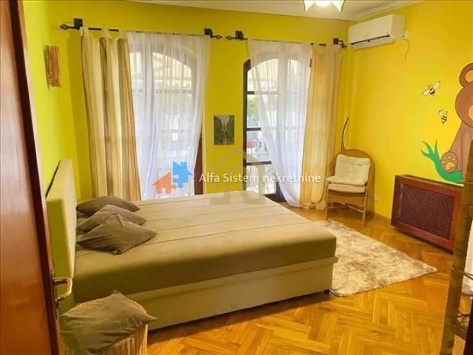 Bedroom with a large double bed, yellow walls and access to the terrace.