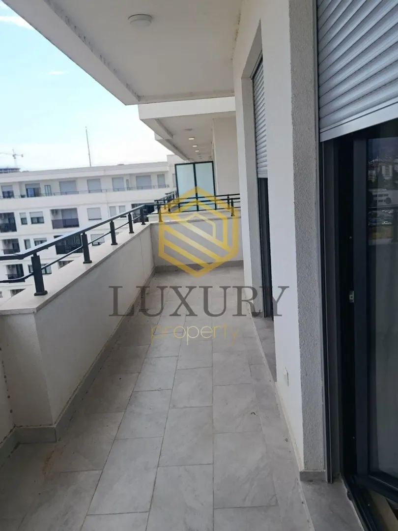 Spacious balcony with a view of surrounding buildings.