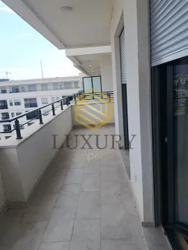 Spacious balcony with a view of surrounding buildings. - image 8