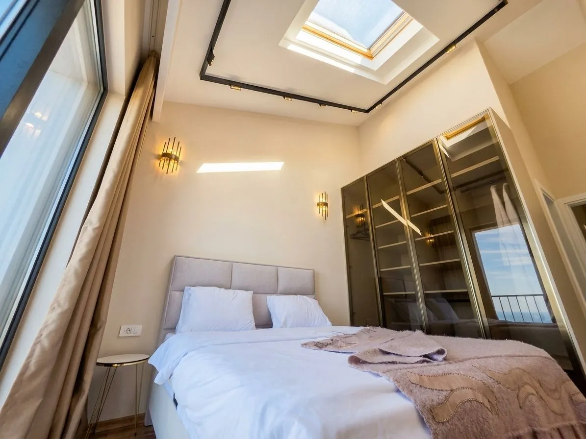 Bedroom with a double bed, large wardrobe, and a skylight.