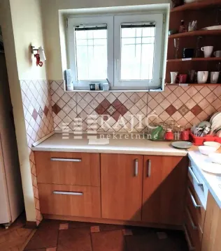 Small kitchen with wooden cabinets and a window above the sink. - image 15