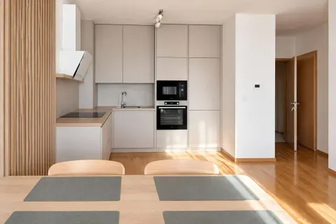 Modern kitchen with built-in appliances and a dining table in the foreground. - image 5