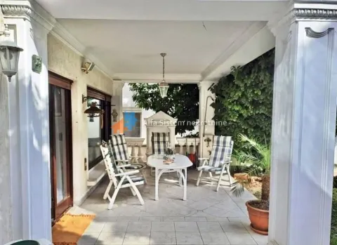 Covered terrace with seating furniture and a view of the yard. - image 27