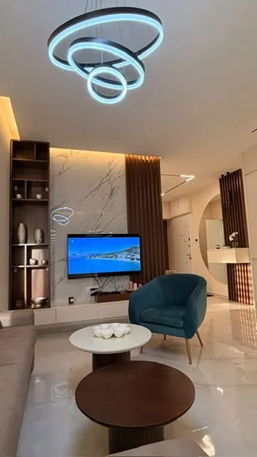 Modern living room with seating, coffee tables, and decorative lighting.