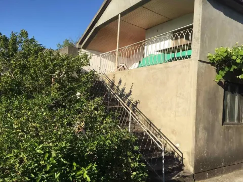 Exterior view of the house with outdoor stairs leading to a spacious terrace. - image 3