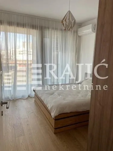 Modern bedroom with a double bed and a large window.