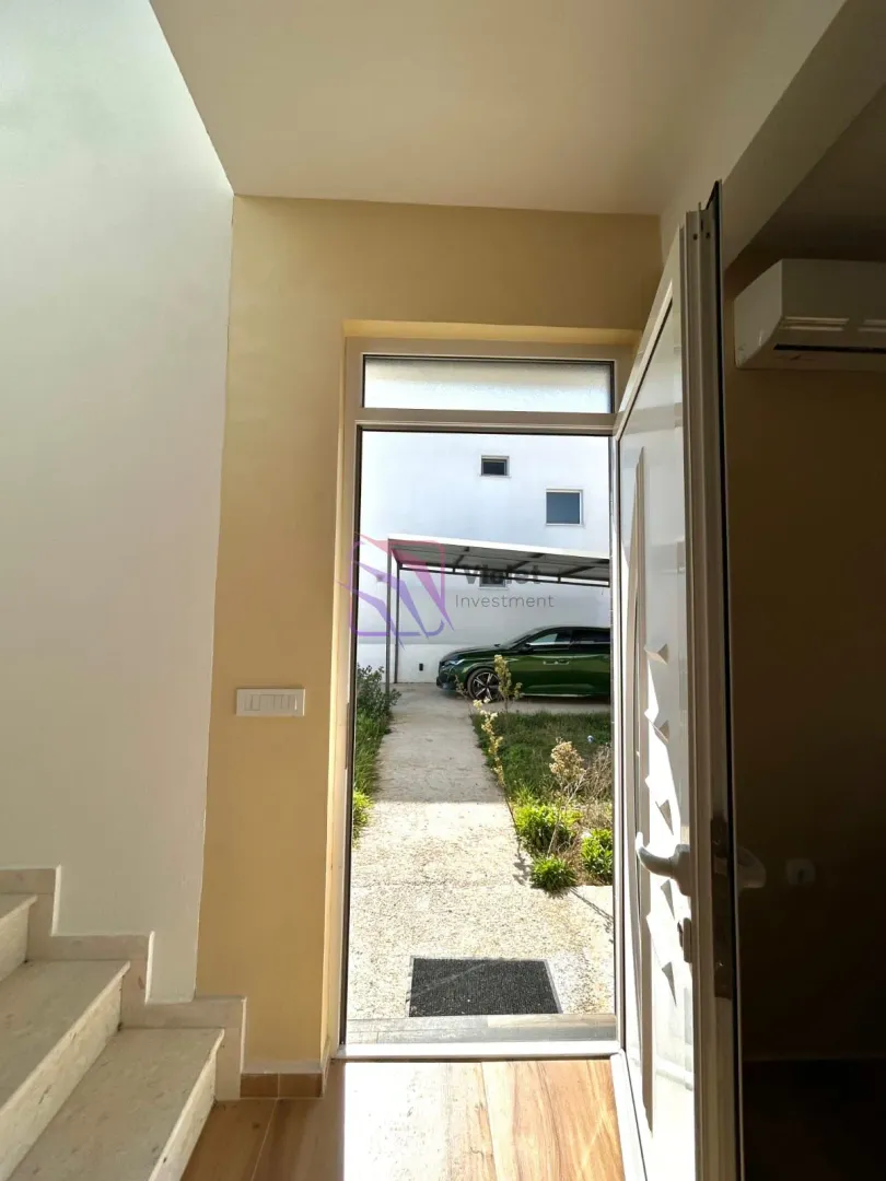 Pogled iz enterijera prema ulaznim vratima i dvorištu kuće.