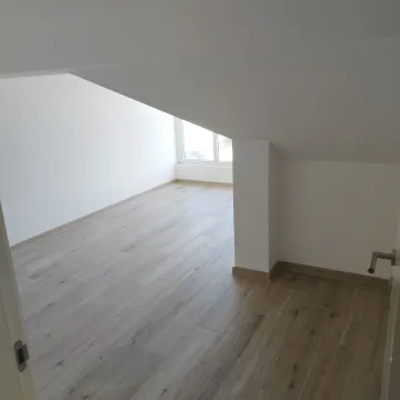 Prazna soba sa laminatom i kosim plafonom. - image 9