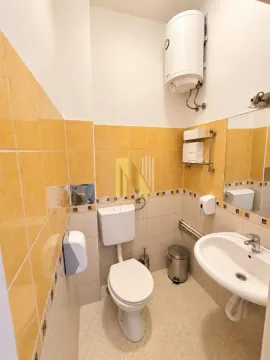 Smaller bathroom with a toilet, washbasin, and water heater. - image 21