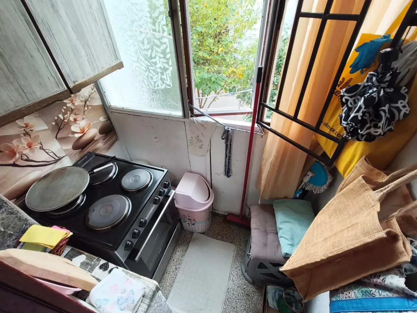 Manja kuhinja sa električnim šporetom i prozorom koji gleda spolja.