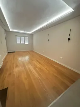 Empty room with wooden flooring and a drop ceiling with lighting. - image 6