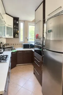 Compact equipped kitchen with dark wooden cabinets and built-in appliances. - image 6